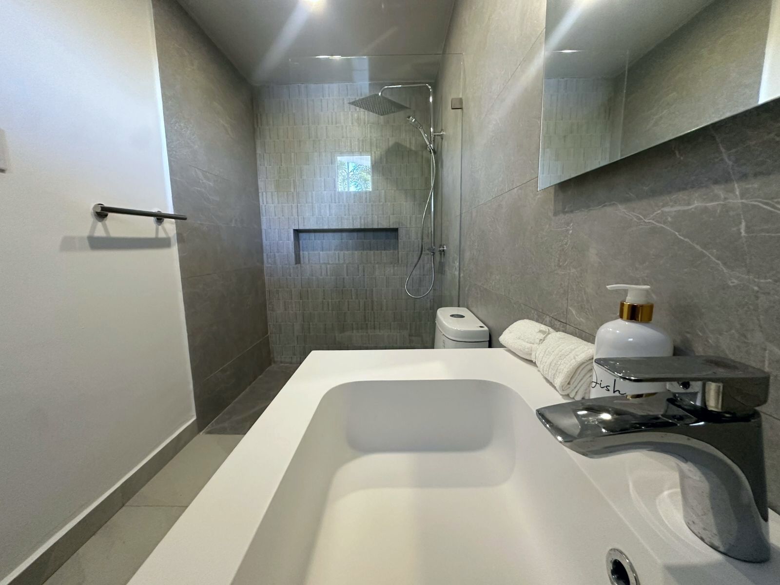 Ein modernes Badezimmer mit einer großen Badewanne, einer Dusche und einem WC.