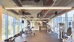 Een sportschool met trainingsapparatuur, grote ramen en een modern industrieel design.