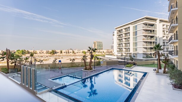 Una piscina sul tetto con vista libera sugli edifici circostanti e palme.