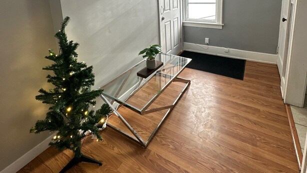 A room with a glass table, a small Christmas tree, and a painting on the wall. - 2 Bedroom Cozy Accomodation (Windsor)