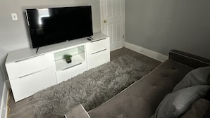 A bedroom with a large bed, a flat-screen TV on a white dresser, a door, and a ceiling light fixture. - 2 Bedroom Cozy Accomodation (Windsor)