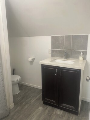 A bathroom with a toilet, a sink, and a cabinet. - 2 Bedroom Cozy Accomodation (Windsor)