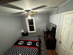 A bedroom with a bed, a ceiling fan, a window, a dresser, and a door. - 2 Bedroom Cozy Accomodation (Windsor)