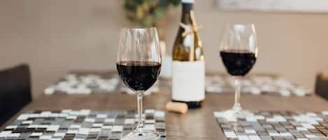 Une table avec deux verres à vin et une bouteille de vin, le tout posé sur une nappe à carreaux.