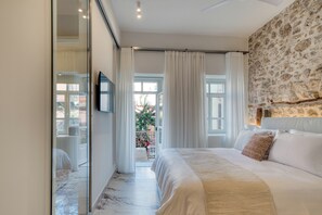 Un dormitorio con una cama grande, una pared de piedra y vistas al exterior.