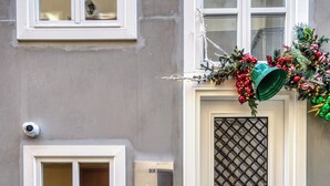 A building facade with a white door, a window with a lattice design, and a mailbox. - Nalia Suites (Nafplio)