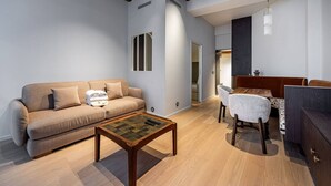Ein modernes Wohnzimmer mit Sofa, Couchtisch und Essbereich mit Tisch und Stühlen.