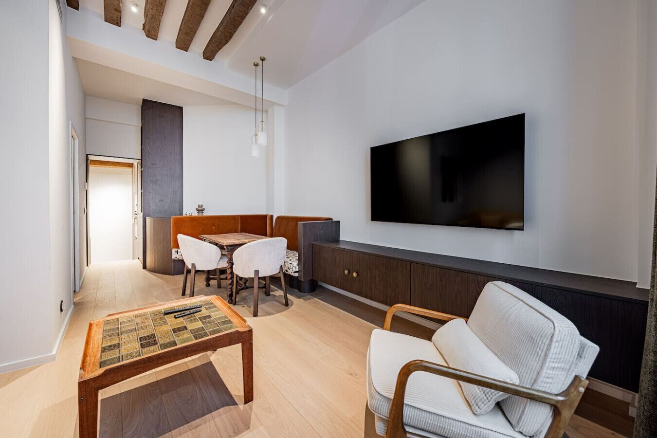 A modern living room with a flat-screen TV, a wooden coffee table, and a sofa.