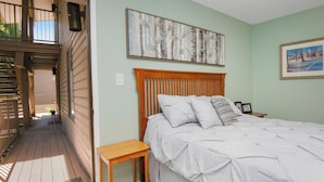 A bedroom with a wooden headboard, a bed with white bedding, a small wooden nightstand, and two framed pictures on the wall. - Après Haus Studio: Lock-off Unit w Pool, Hot Tubs, Sauna and Vail + BC Shuttle (Avon)