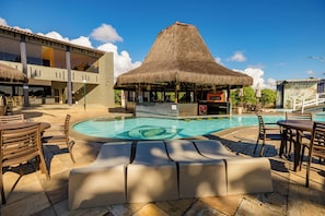 A pool area with a thatched-roof structure, lounge chairs, and a bar. - El Aram Beach Cabo All Inclusive (Cabo de Santo Agostinho)