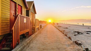 Un bâtiment en bois doté d’une terrasse qui donne accès à une plage.