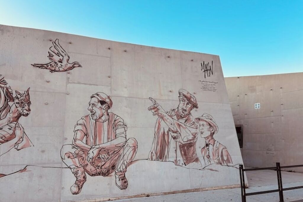 A mural on a concrete wall with figures in various poses.