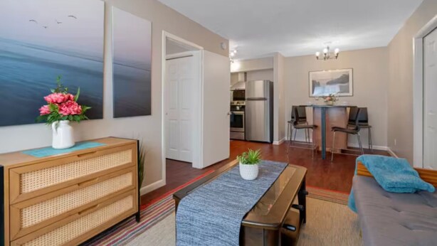 A modern apartment with a dining area, kitchen, and living room.