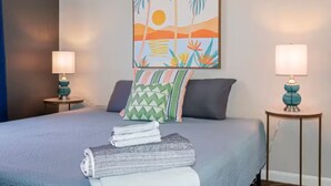A neatly made bed with pillows, a folded blanket, and a lamp on each side.