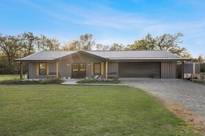 Un bâtiment moderne doté d’un garage, d’une allée couverte et d’une pelouse bien entretenue.