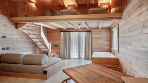 Ein Holzinterieur mit einer Couch, einem Esstisch und einer Treppe.