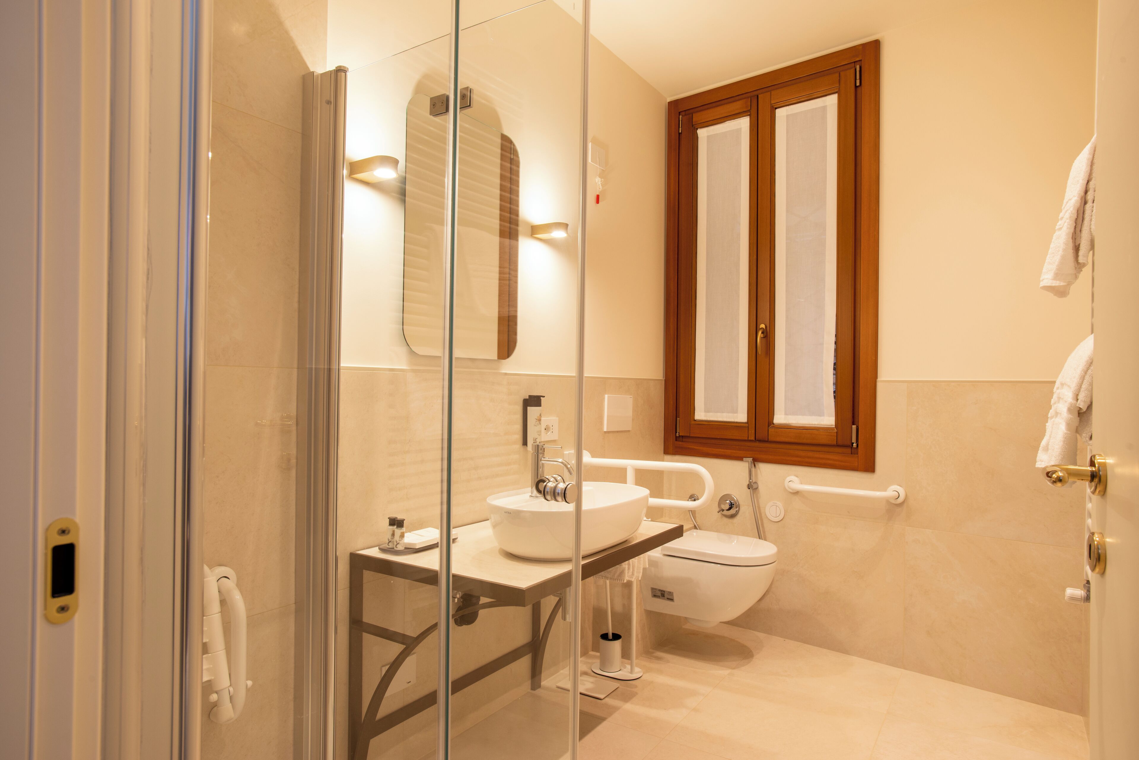 A modern bathroom with a glass-enclosed shower, a sink, and a toilet.