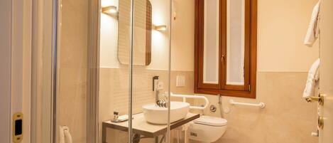 A modern bathroom with a glass-enclosed shower, a sink, and a toilet.