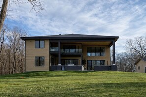 A modern two-story house with a flat roof, large windows, and a covered front porch. - Vacation home on Alexandria chain of lakes. (Alexandria)