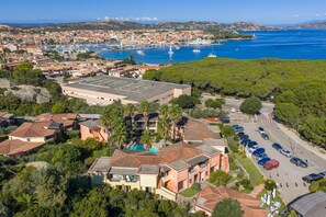 An aerial view of a coastal town with residential buildings, a marina, and a clear blue sea. - Calm Escape in Seaside Resort (Palau)