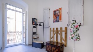 A room with a sliding glass door, a black metal rack, a wooden cabinet, a mannequin, and a painting on the wall. - GuestHost - Charming 74 sqm apartment, ideal for groups or families of up to 4 guests, located on the first floor of a building (a few steps to access / NO elevator).The accommodation is located in a very central area, just a few minutes’ walk from the (Taranto)