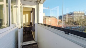 A balcony with a view of a building and trees.