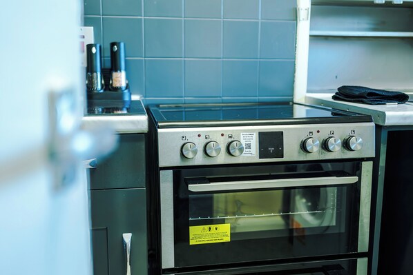 Una cocina con horno empotrado y microondas.