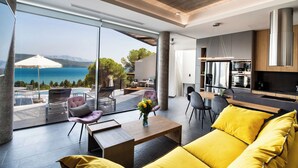 Un salon moderne avec un canapé jaune, une table basse et une vue sur la mer.