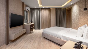 A modern hotel room with a flat-screen TV, a desk, a bed, and a telephone. - Atlanticblu Hotels & Resorts (Abuja)