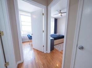 Un dormitorio con cama, ventilador de techo y ventana con cortinas.