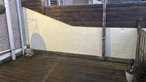 A wooden gate leading to a residential area with a paved path and a statue. - 16 Salvin Terrace (Stockton-on-Tees)