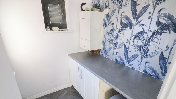 A compact kitchen with white cabinets, a grey countertop, and a trash bin. - 16 Salvin Terrace (Stockton-on-Tees)