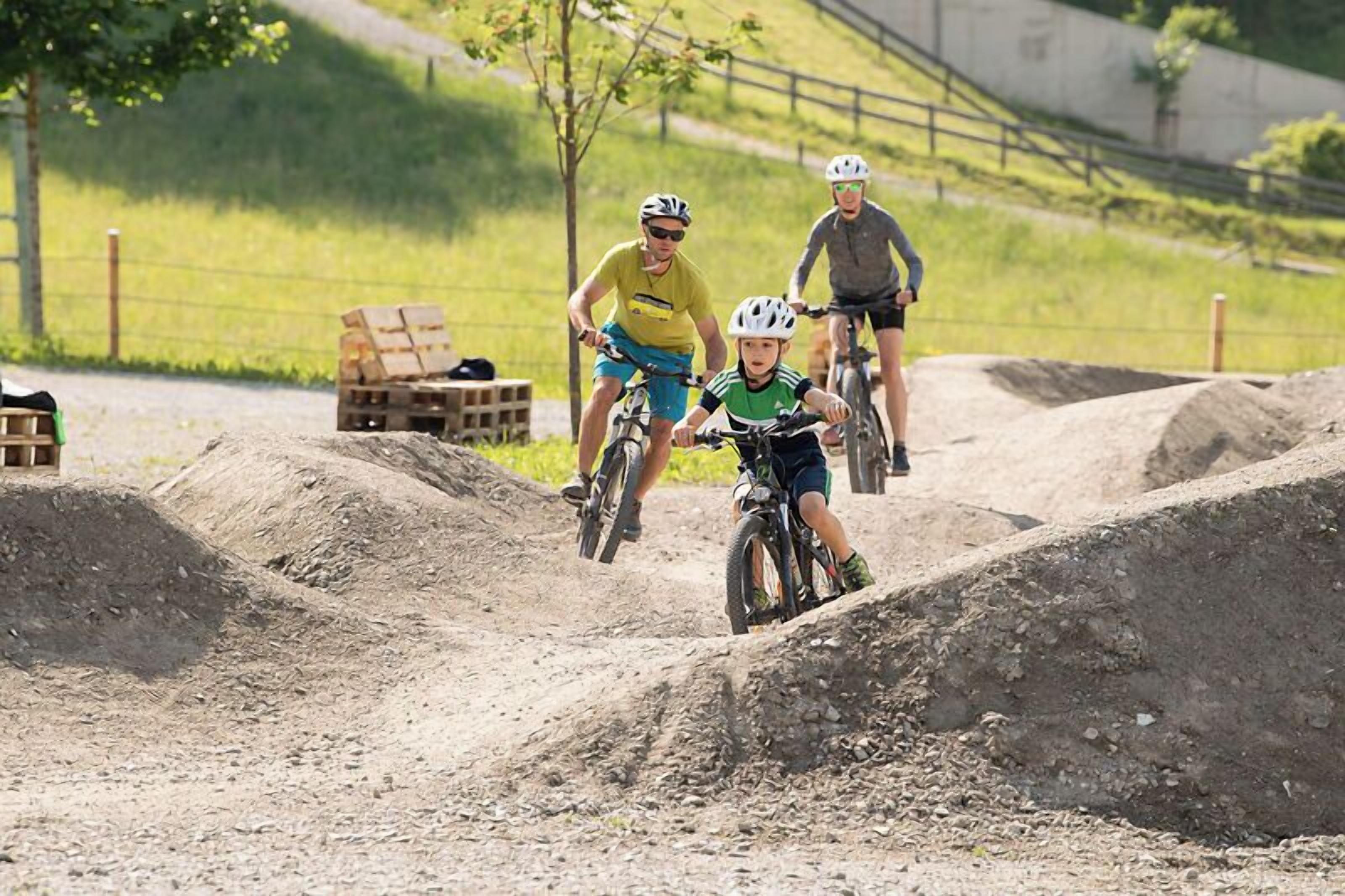 Una pista de motocross amb pilots i un nen.