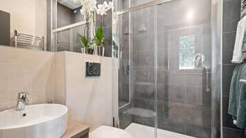 Appartement | Badkamer | Een douche, een haardroger, handdoeken, zeep