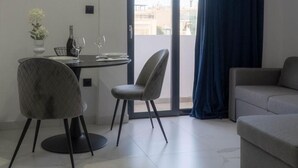 A modern living room with a dining area, a sofa, and a balcony with a view. - Apartment 'Deluxe' with Sea View, Wi-Fi and Air Conditioning (Ρόδος)