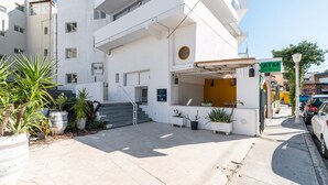 A white building with an ATM, outdoor seating, and potted plants. - Apartment 'Double Room Mountain View' with Sea View, Wi-Fi and Air Conditioning (Ρόδος)