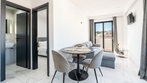 Ett modernt hotellrum med en matplats, en soffa och en TV.