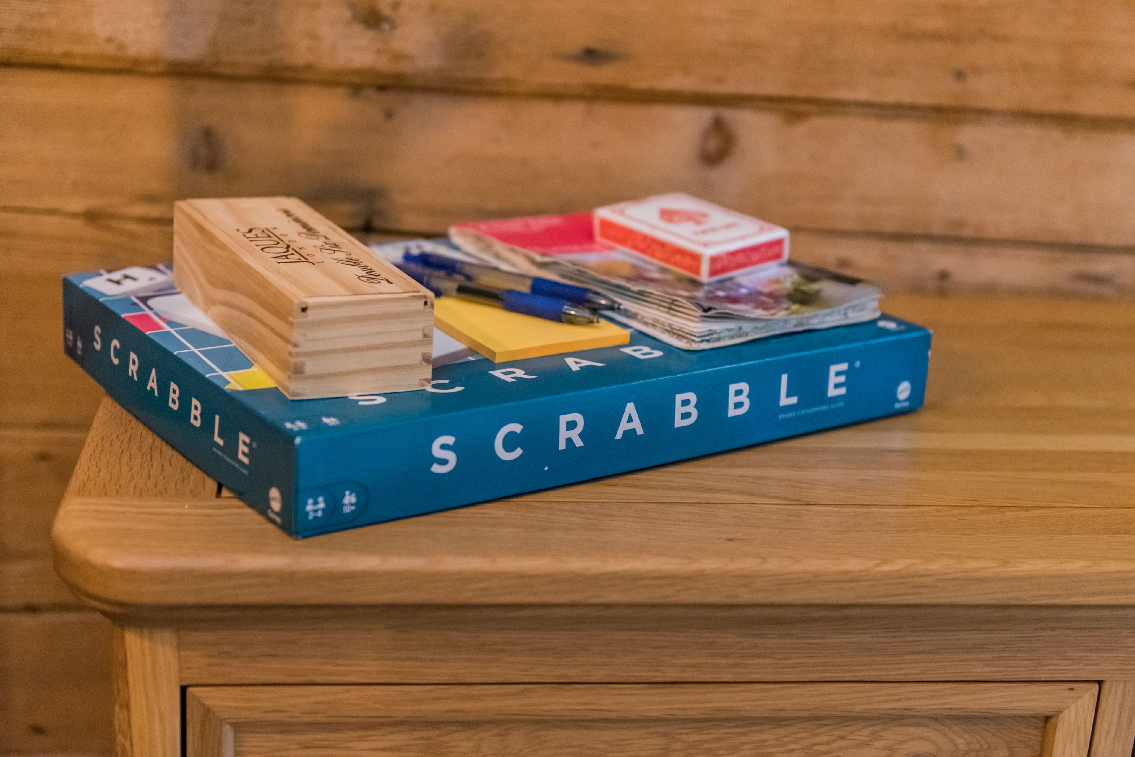 Eine Scrabble-Spielbox auf einem Holztisch.