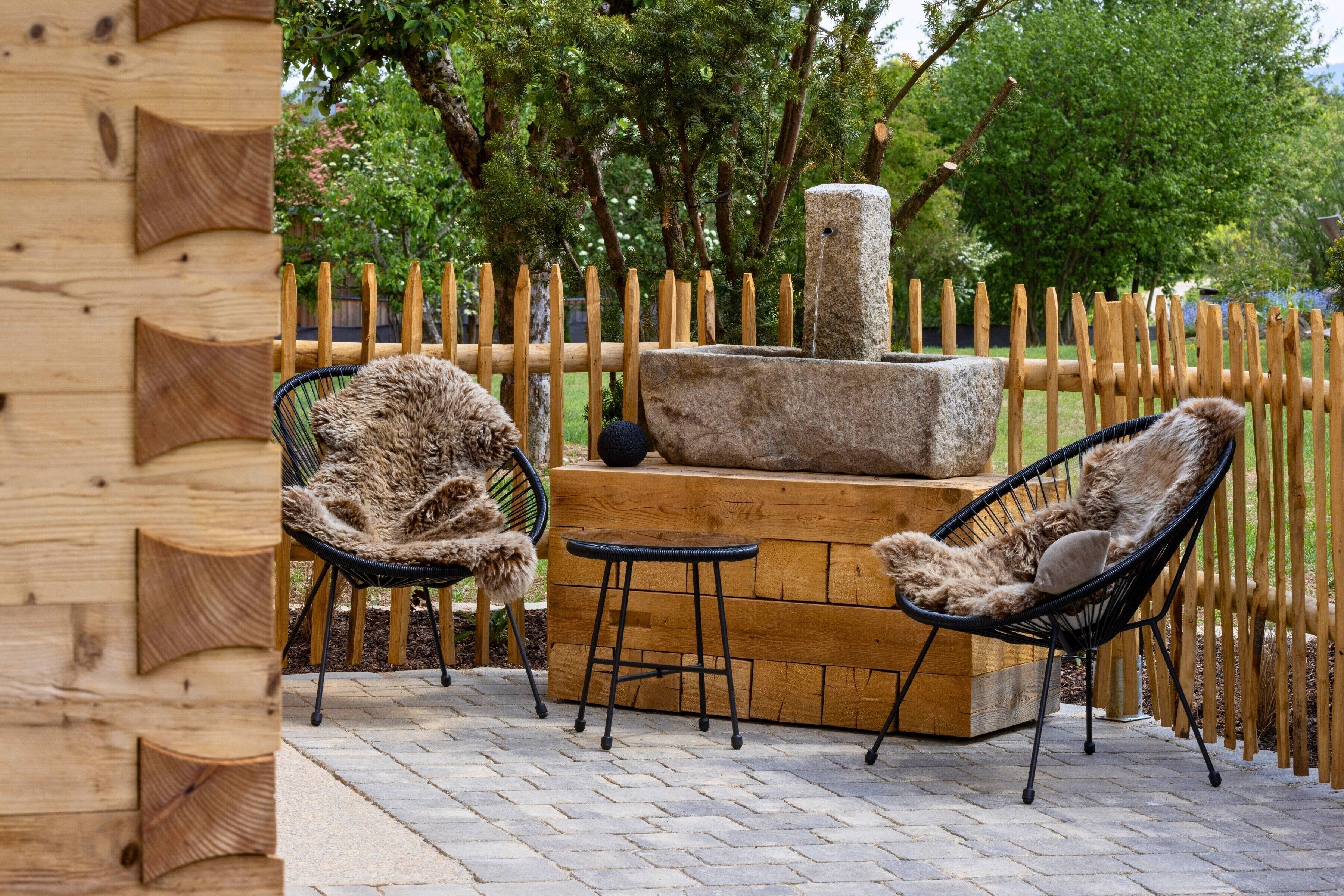 Una valla de madera, una chimenea de piedra y dos sillones con tapicería de piel.