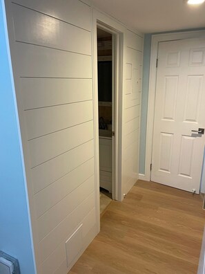 A hallway with a closet, a door, and a light fixture. - Penthouse Beach Condo-Sunset Views & Sea Breezes! (Wildwood)