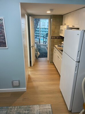 A narrow hallway leading to a bedroom with a view of a building outside. - Penthouse Beach Condo-Sunset Views & Sea Breezes! (Wildwood)