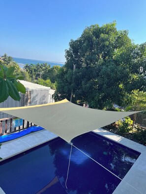 A swimming pool with a view of the sea and trees in the background. - Third Base (La Libertad)
