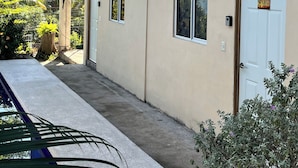 A building with a blue balcony, a white door with a sign, and a small window. - Third Base (La Libertad)