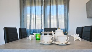 A dining table with white teacups and saucers, a teapot, and a green canister. - Villa Donato (Filiano)