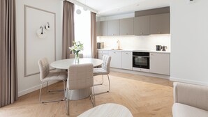 A modern kitchen with white cabinets, a built-in oven, and a coffee maker. - Native Apartments Prądnicka 48 (Kraków)