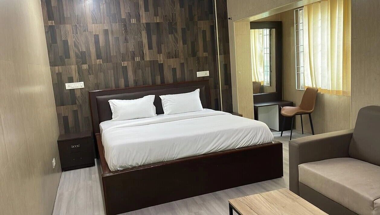 Una habitación de hotel moderna con una cama grande, un escritorio y un sofá.