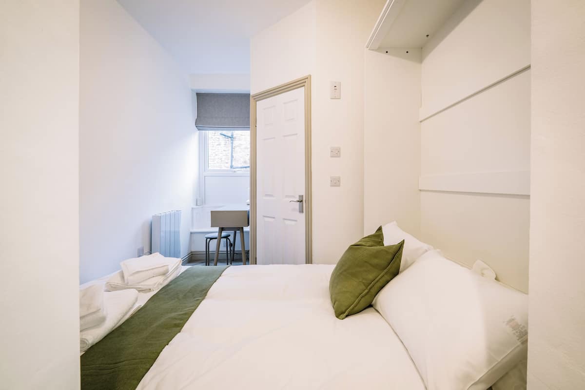 Een hotelkamer met een bed, een bureau en een stoel.