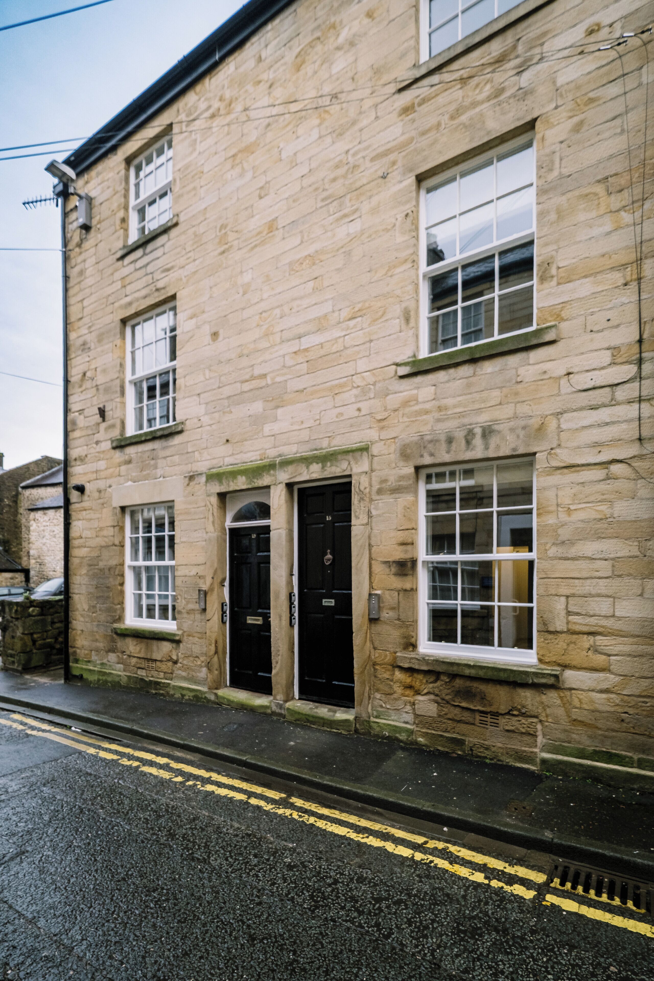 A stone building with a black door and windows.