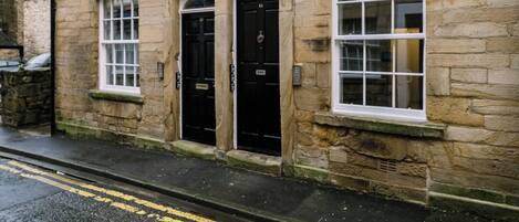 A stone building with a black door and windows.