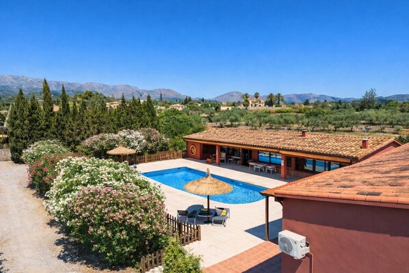 Une villa avec piscine, un espace salon extérieur et une vue sur les montagnes.